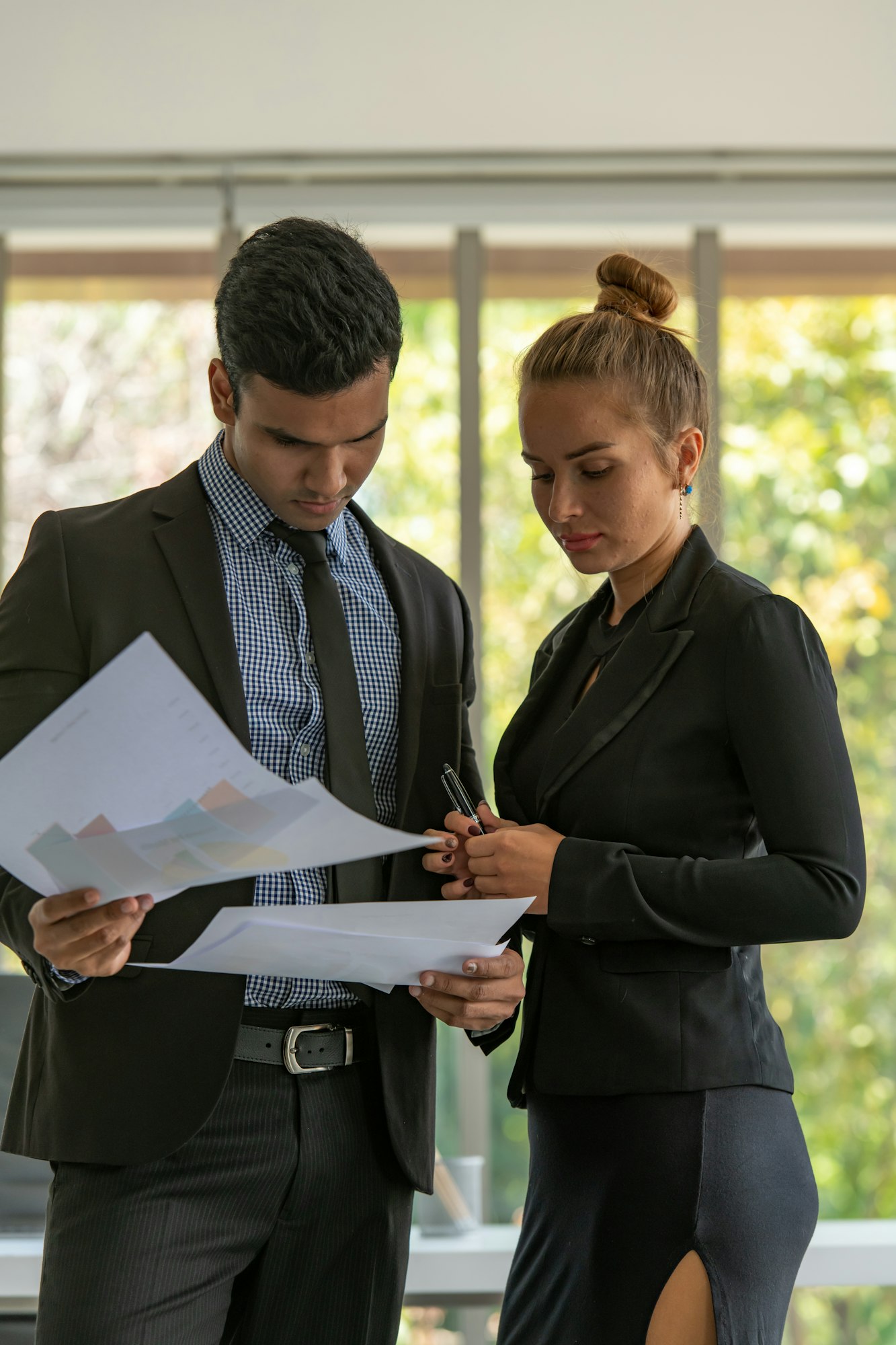 Both of young business analyze data and consult various issues